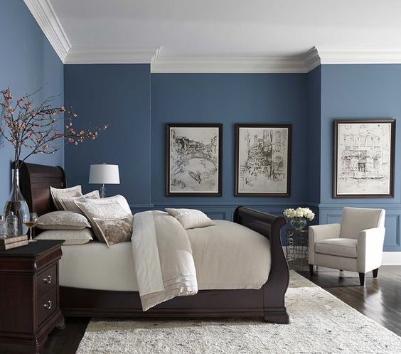 Bedroom with blue accents, neutral linens and fantastic wall sconce features. Modern Side Tables and interesting artwork